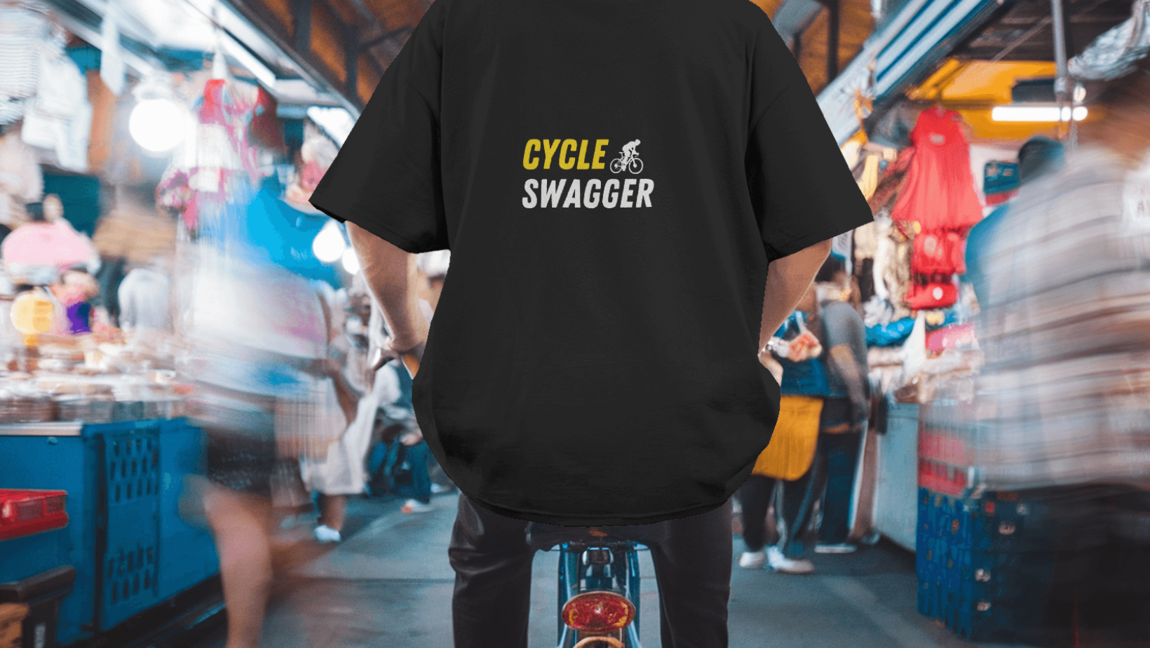 Cycle Swagger banner: Cyclist wearing a black T-shirt with the Cycle Swagger logo, riding through a bustling, motion-blurred urban market, showcasing an active cycling lifestyle.