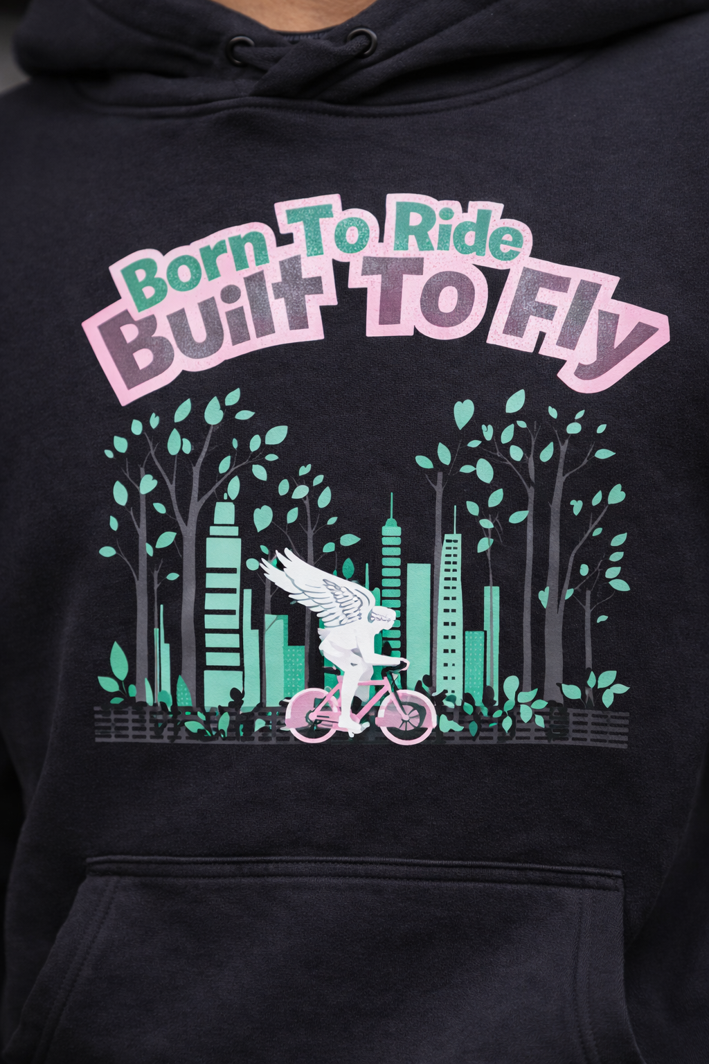 Black hoodie with graphic design of a person on a bicycle with wings, trees, and buildings, and text 'Born To Ride Built To Fly'.
